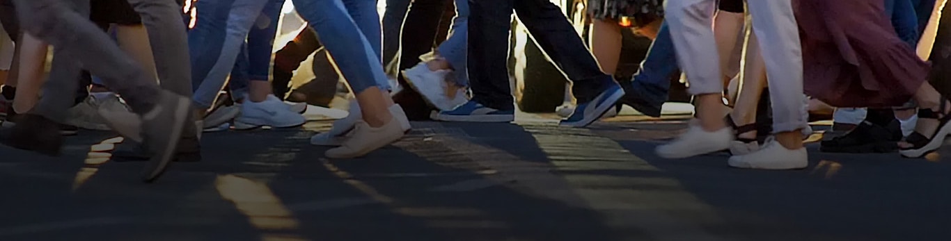 Uma passadeira de uma cidade que mostra dezenas de pessoas a caminhar em direções opostas enquanto atravessam a rua