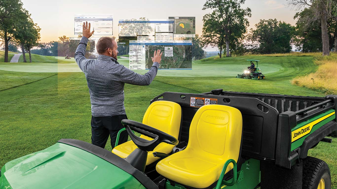 Um greenkeeper está a utilizar monitores inteligentes no exterior de um campo de golfe para a manutenção dos greens.