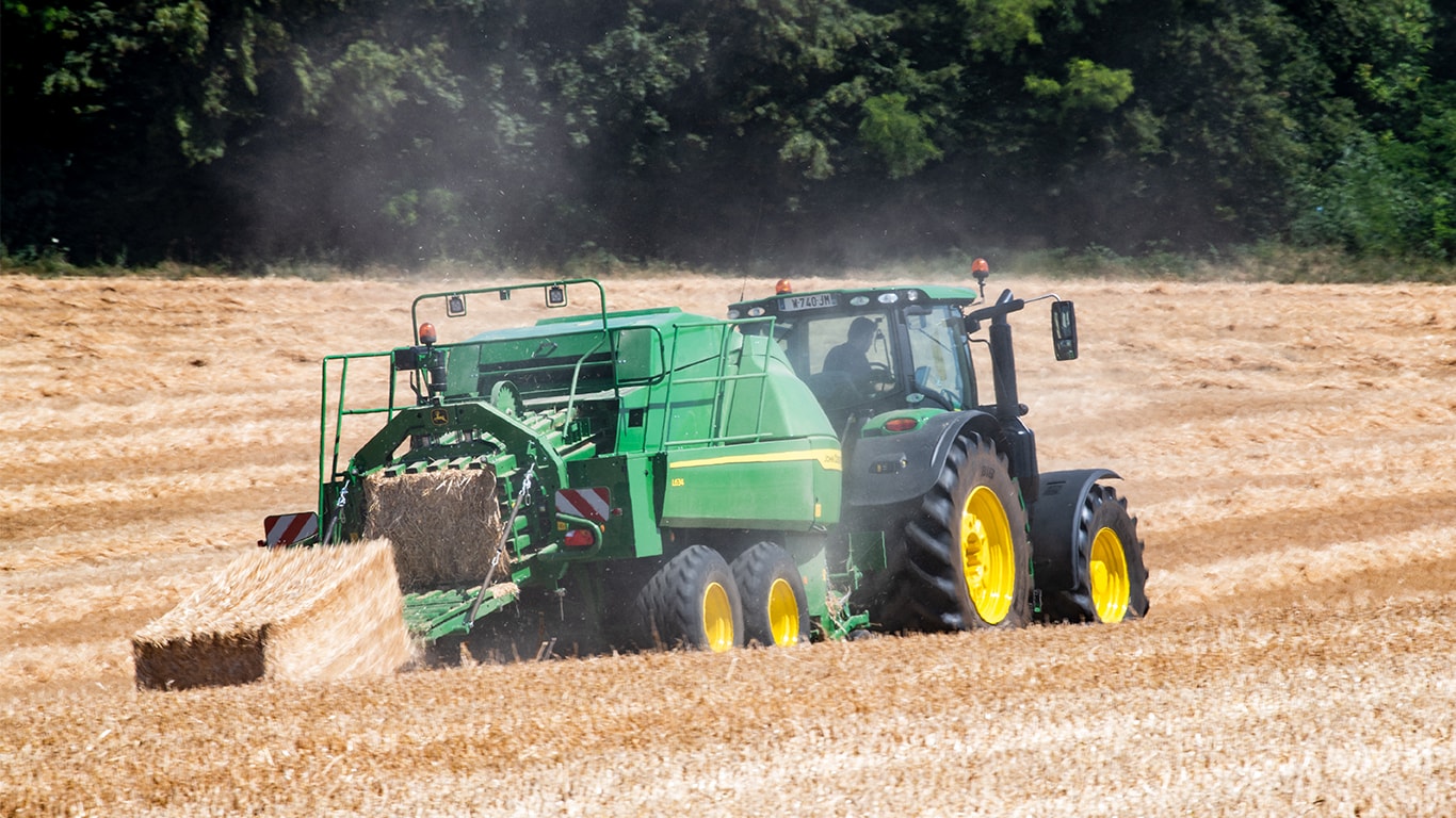 Macro-enfardadeira L634 da John Deere com trator 6R na palha